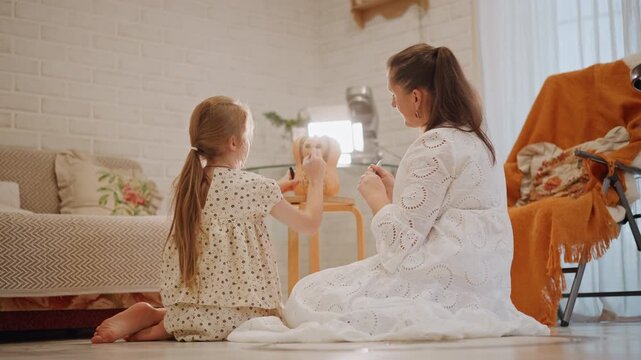 White mother and daughter kneel together by low table mixing pumpkin pie filling, sunlit living room, home baker guiding child through recipe and tradition, warm orange throw and candle decor creating