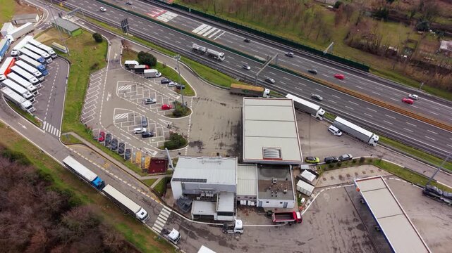 Logistics Hub Aerial View: An aerial perspective unveils a busy logistics hub, showcasing a complex network of semi-trucks, infrastructure, and the constant flow of goods.