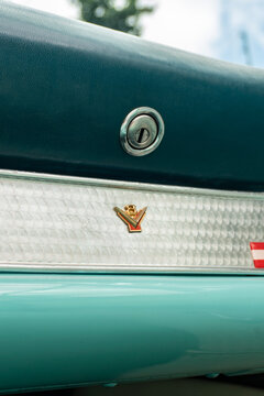 Turquoise Ford Thunderbird glovebox lock and V8 emblem detail, Classic vintage car interior details