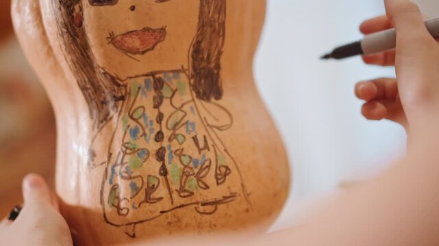 Cozy autumn craft inspiration. Colorful handmade pumpkin dress drawing with cozy seasonal ambiance. Creative DIY project featuring pumpkin themed art with warm autumn tones and folk patterns