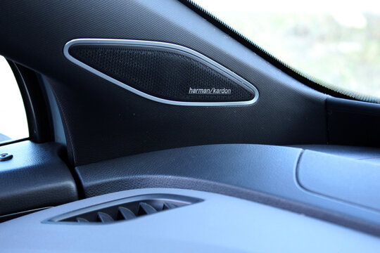 Vinnytsia, Ukraine; March 28, 2026. Volkswagen ID.4 Pro speaker by Harman Kardon audio system. Close-up of black textured dashboard speaker in Volkswagen ID.4. Oval Harman Kardon grille with silver me