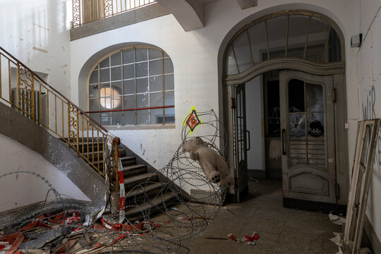 Verlassenes Treppenhaus mit Stacheldraht und zerst&ouml;rter Treppe in altem Geb&auml;ude
