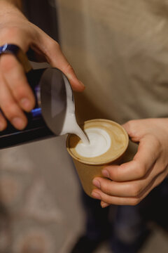 close up of a man making a cup of coffee to go