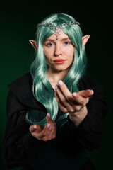 Obraz premium Beautiful girl dressed as elf on dark green background