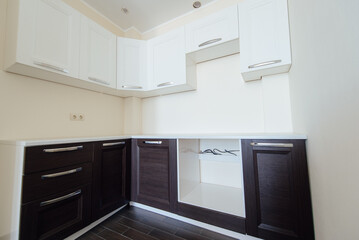 Fototapeta premium Modern kitchen interior with white and dark wood cabinets and countertop