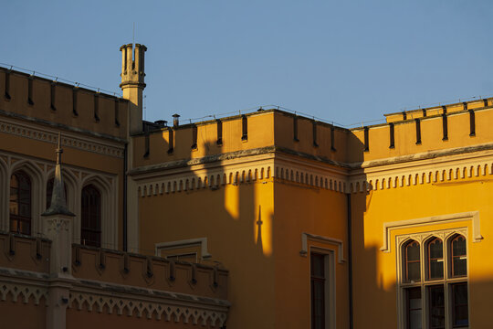 Sunlit yellow historic facade with crenellated parapet