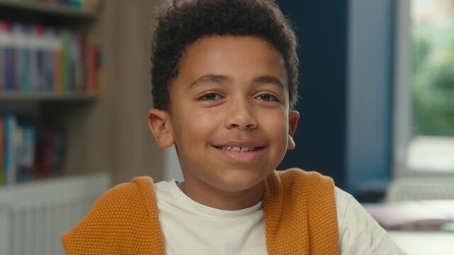 African American little cute boy pupil smiling with healthy teeth in school at home closeup positive ethnic kid child son smile toothy looking at camera enjoying studying primary study happy childhood