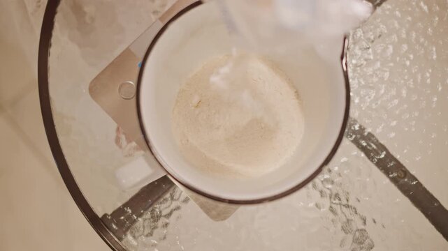 Topdown shot measuring sugar in mug, digital scale under glass table, steady pour, enamel mug rim, pastry chef preparing pumpkin pie crust, clinical warm light, granules settling into measured portion