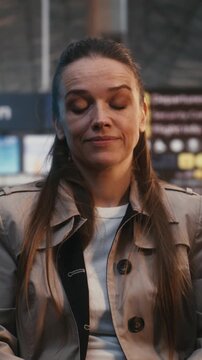 Feeling Uneasy In Restless Airport Atmosphere, Woman Remains Calm Escape Surrounding Stress. Body Language Suggests Flight Response Crowds Energy as Desperately Waits For Boarding Call. Vertical Shot.