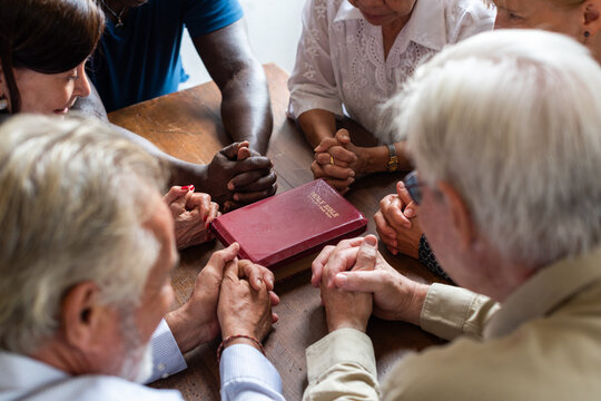 Group prayer around Bible