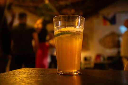 Fotografia colorida de copo americano com bebida ou drink com lim&atilde;o e gelo em bar noturno 
