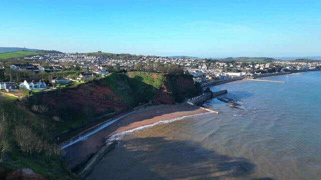 Dawlish, Devon, England: DRONE VIEWS: An intercity train passes through a cliff tunnel on its way towards Dawlish railway station. Dawlish is a popular UK tourist destination on the mainline railway. 