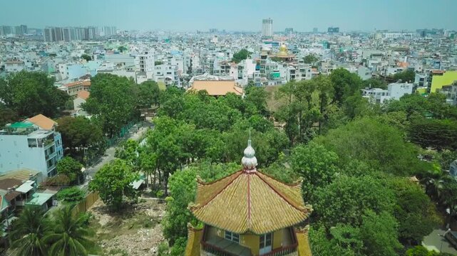 Aerial view flying up past giac lam pagoda revealing the ho chi minh city skyline in vietnam