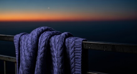 Naklejka premium A thick knit covering rests against a cold railing on a high terrace during twilight, capturing a mood of deep isolation and quiet sorrow, railing, still, nocturnal