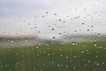 Raindrops on a window with a blurred view of an airfield © Tsyb Oleh
