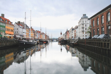 Fototapeta premium Reflections of Nyhavn canal and colorful buildings in Copenhagen