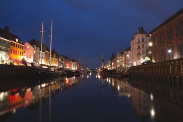 Fototapeta premium Night view of Nyhavn canal with lights and reflections in Copenhagen