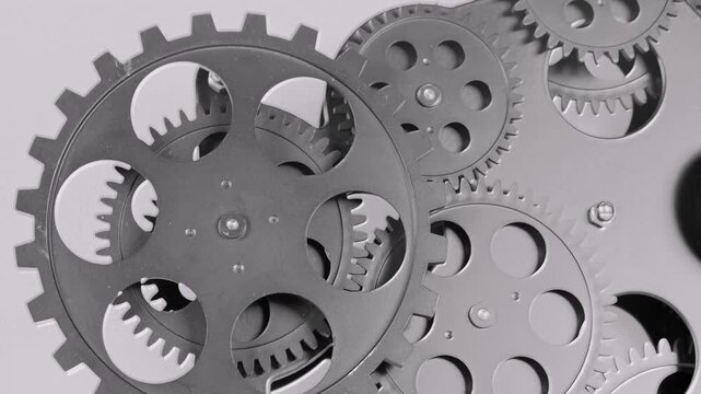 Close-up of rotating metal gears in a mechanical system. Industrial machinery concept with interlocking cogwheels, precision engineering, and smooth motion.