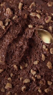 Close-up of chocolate mixture with hazelnuts and kataifi. Rich textured dessert preparation inspired by Middle Eastern sweets.