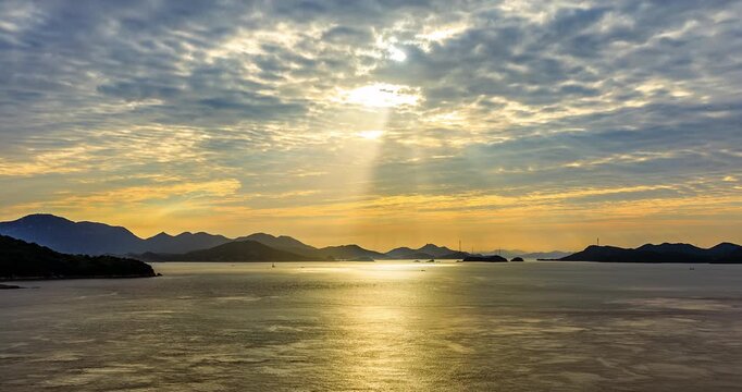 Panoramic view of golden sunset over the ocean with island silhouettes at golden hour