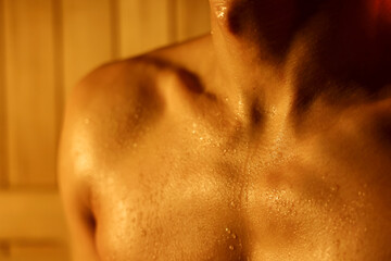 Naklejka premium Muscular man with drops of sweat in sauna, closeup