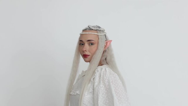 Beautiful girl dressed as elf on white background