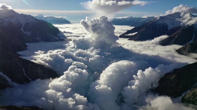 Advancing dense clouds spilling through alpine valley, with central plume and snow-dusted ridges