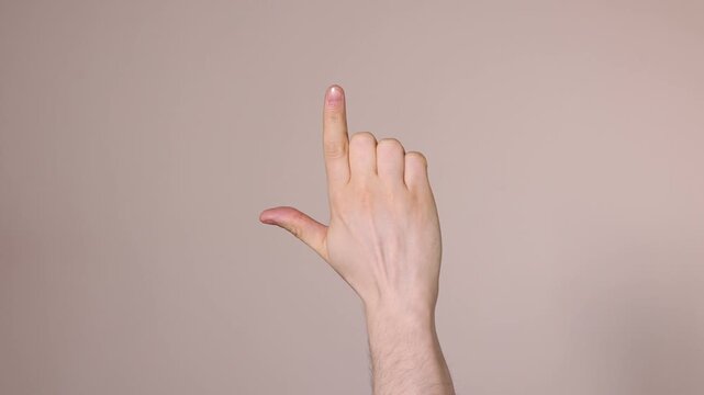 Man pointing at something on beige background, closeup