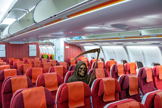 A hooded grim reaper with a skeletal face and a scythe sits among the empty red seats of the plane