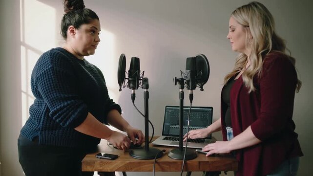 Two co-hosts adjusting mics and cables, starting software, animated waveforms showing podcast start