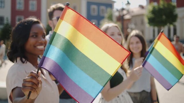 Waving woman holding pride flag at plaza, celebrating with group in summer clothes, copy space