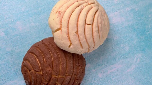 Close-up of authentic artisan sweet bread, pan dulce Mexicano. Conchas on a blue marble background
