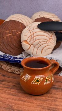 Mexican food, hand places a vanilla concha bread on a plate using silicone tweezers