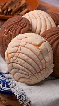 Mexican food, variety of vanilla and chocolate conchas on a cloth napkin, traditional Mexican bread