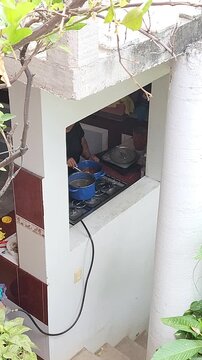 Voyeuristic View Through Window of Woman Cooking in Kitchen