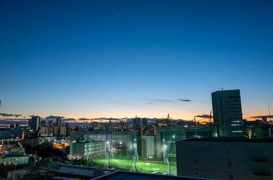 日が沈みかけた空とゴルフの練習場