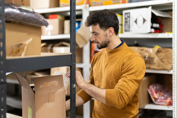Fototapeta premium Male worker loading box at warehouse store