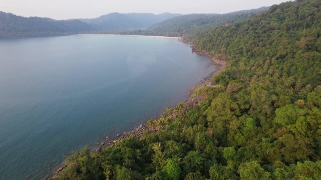 Dense Tropical Forest On Rocky Shoreline Of Ao Jark Bay On Koh Kood Island In Thailand. wide aerial shot