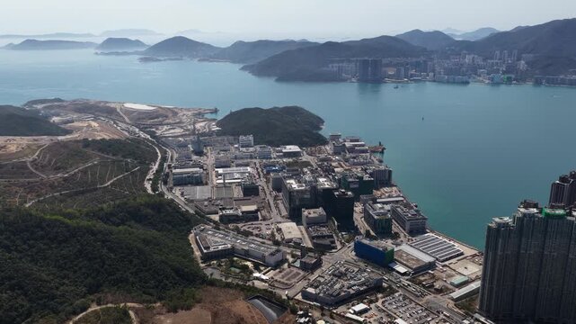 Stunning aerial perspective of the tseung kwan o industrial estate and junk bay, showcasing the modern architecture against the backdrop of serene mountains and the south china sea in hong kong