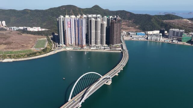 Stunning aerial perspective showing the modern tseung kwan o cross bay link bridge connecting lohas park with the developing waterfront residential area on a sunny day in hong kong