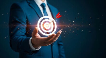 Fototapeta premium Businessman in blue suit holding glowing target with arrow