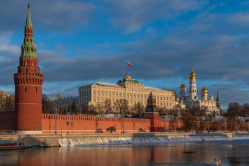 Fototapeta premium Vodovzvodnaya and Annunciation Towers of the Kremlin Wall, the Grand Kremlin Palace and the Kremlin Embankment of the Moskva River on a sunny winter day, Moscow, Russia