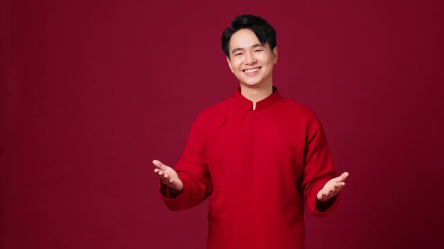 Asian man smiling with hands together, calm and respectful New Year mood. Saying New Year's greetings in Vietnamese