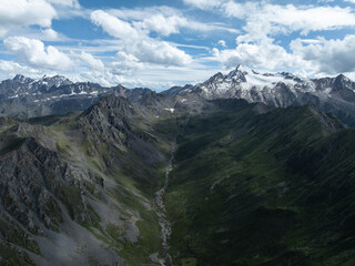 Obraz premium Aerial view of beautiful high altitude snow capped mountain and forest landscape