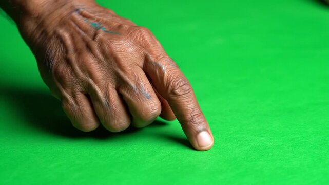 A close-up shot of a person's finger pointing on a green snooker table felt.
