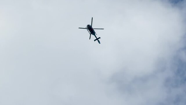 Police Helicopter Flying Through Partly Cloudy Blue Sky in Tokyo