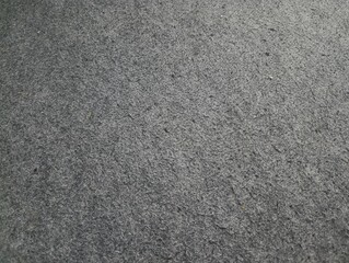 Fototapeta premium Abstract dark grey felt fabric texture. Rough rugged surface background design.