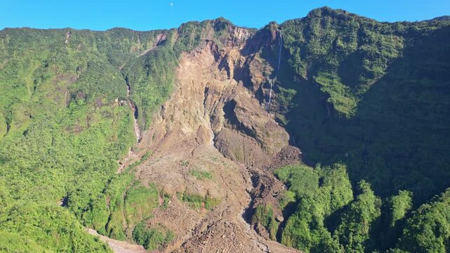 Aerial drone footage of inside the Galunggung volcano mountain crater, at early sunrise, with raw stones and destroyed side, sunny weather, in Tasikmalaya regency, Java island, Indonesia