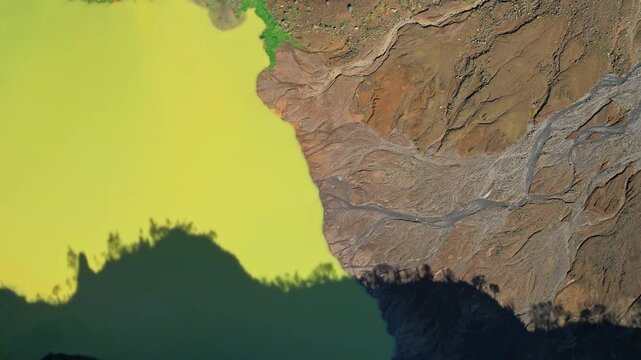 Aerial drone footage from above of the Galunggung volcano mountain yellow sulfuric lake, rocky parts and river, and tree shadows, at early sunrise, in Tasikmalaya regency, Java island, Indonesia