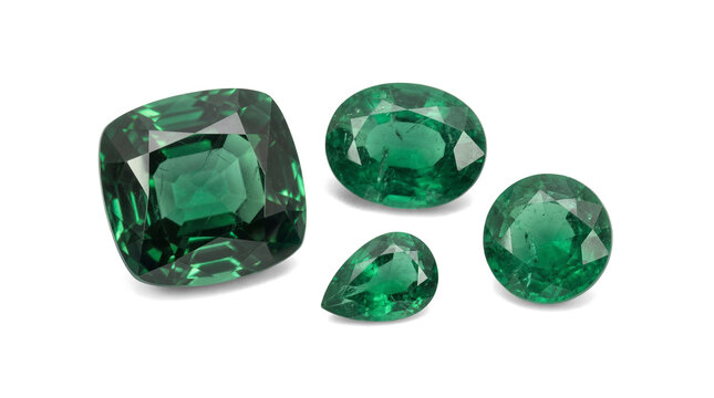 Four brilliant green emerald gemstones, meticulously cut into cushion, oval, pear, and round shapes.